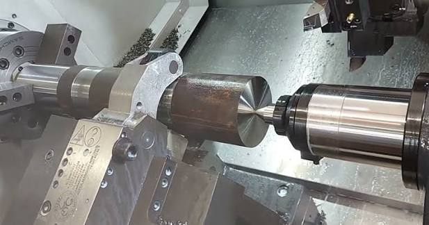 CNC lathe turning a metal shaft